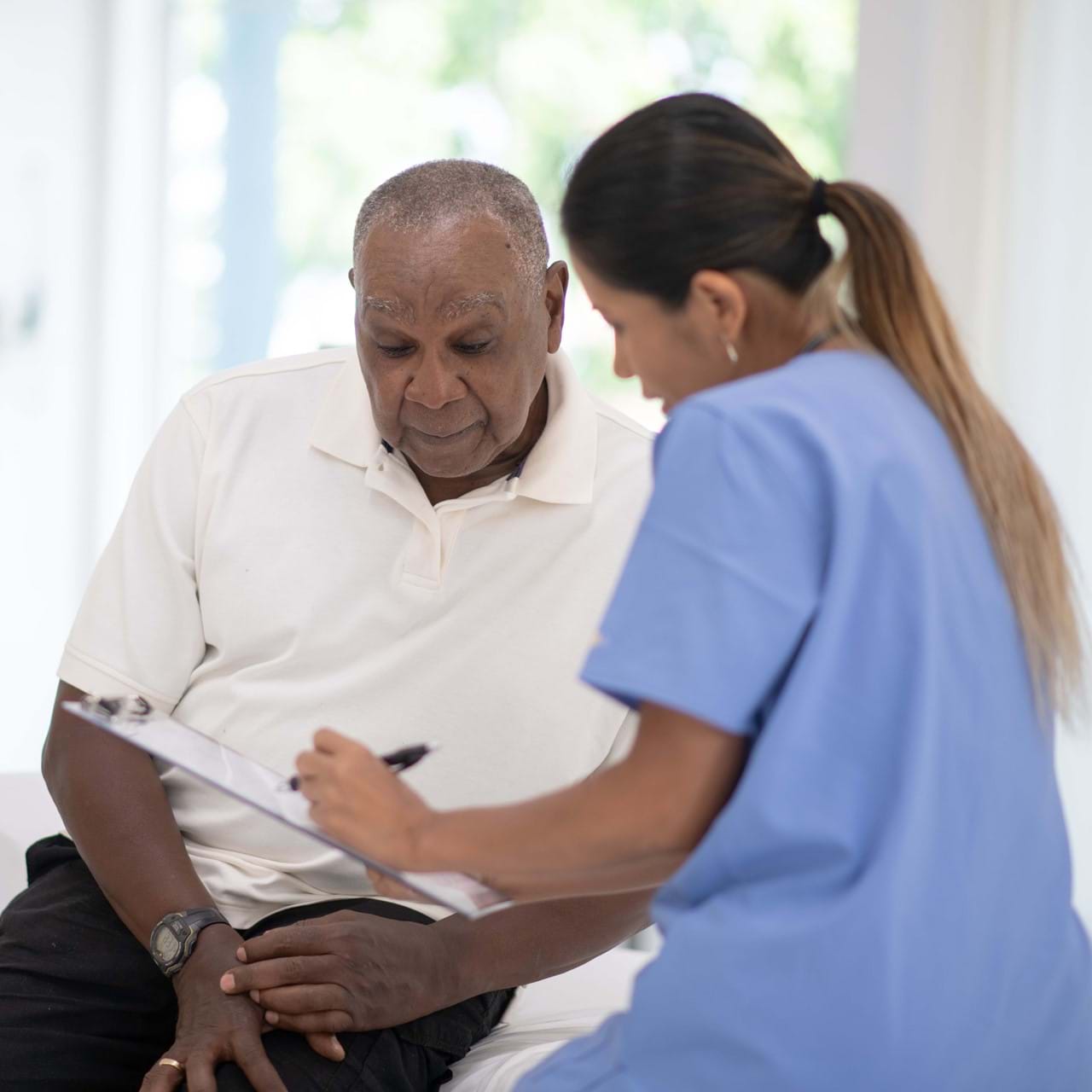 Medical staff talking with elderly patient